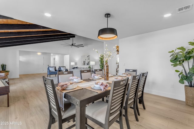 dining room with ceiling fan, light hardwood / wood-style floors, and vaulted ceiling with beams