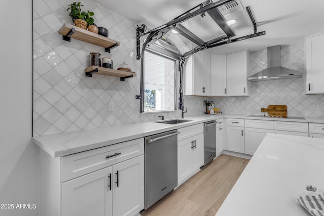 kitchen with dishwasher, wall chimney range hood, decorative backsplash, white cabinets, and sink