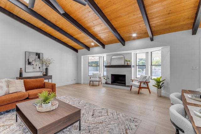 living room with vaulted ceiling with beams, light hardwood / wood-style floors, and wood ceiling