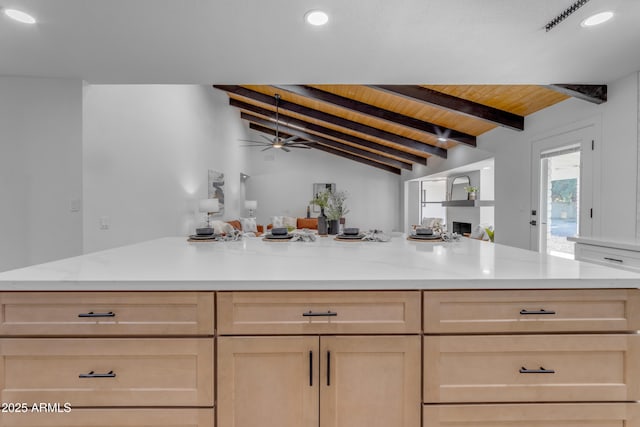 kitchen with wooden ceiling, lofted ceiling with beams, light stone countertops, ceiling fan, and light brown cabinetry