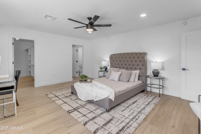 bedroom featuring ceiling fan, a spacious closet, a closet, and light wood-type flooring