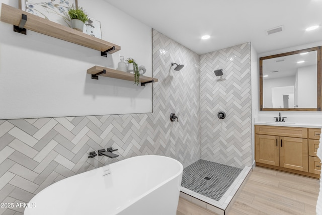 bathroom featuring wood-type flooring, vanity, and shower with separate bathtub