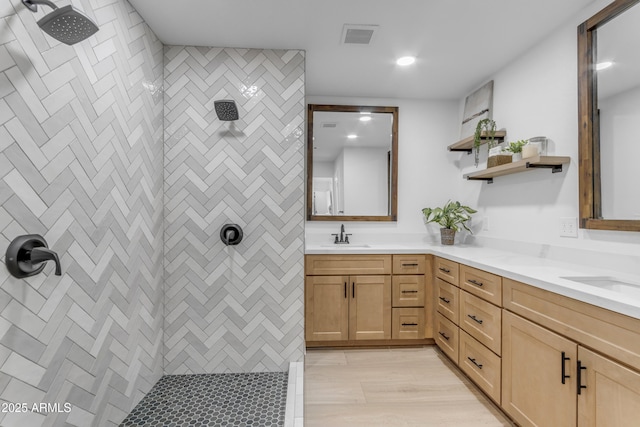 bathroom featuring a tile shower and vanity