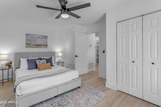 bedroom with ceiling fan, light hardwood / wood-style floors, and a closet