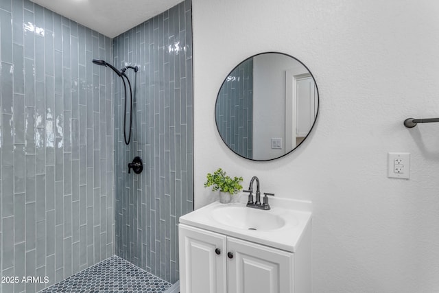 bathroom with vanity and tiled shower