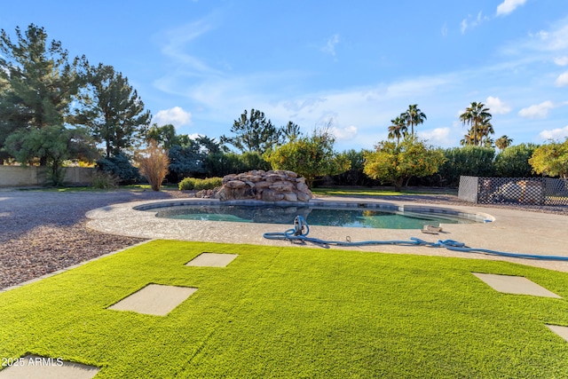 view of pool with a yard