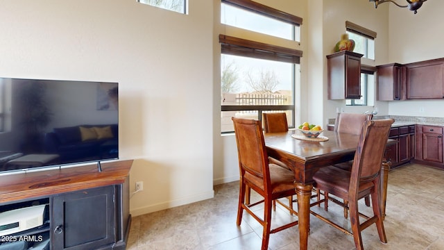 dining space with baseboards and a high ceiling