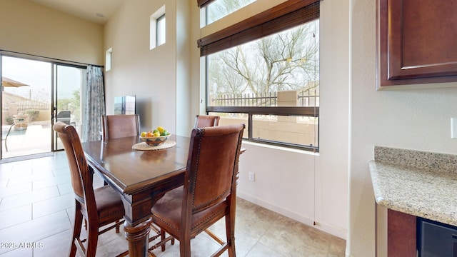 dining space featuring light tile patterned floors and baseboards