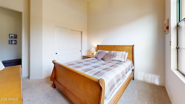 carpeted bedroom featuring a closet and baseboards