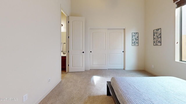 unfurnished bedroom with a closet, baseboards, and light carpet