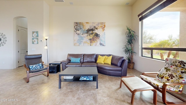 living room featuring light tile patterned floors and arched walkways