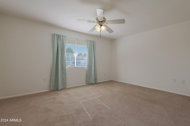 carpeted spare room featuring ceiling fan