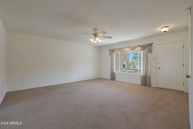 empty room featuring ceiling fan and light colored carpet