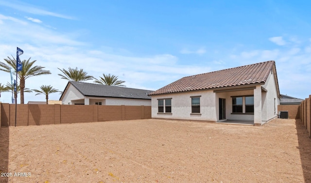 42405 W Peters Dr, Maricopa, AZ 85138 - rear view of house featuring a tiled roof, stucco siding, central AC, and a fenced backyard