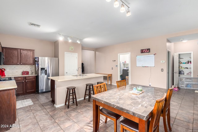 dining space with sink, track lighting, and light tile patterned floors