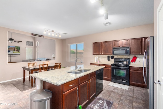 kitchen featuring a center island with sink, ceiling fan, backsplash, black appliances, and sink