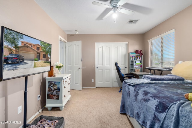 bedroom featuring a closet, light colored carpet, and ceiling fan