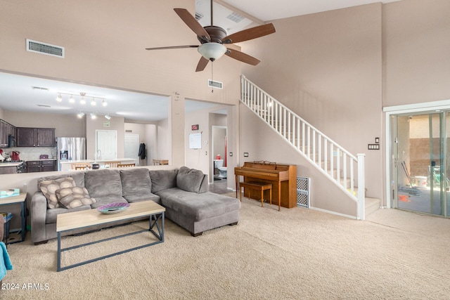 living room with light carpet, high vaulted ceiling, track lighting, and ceiling fan