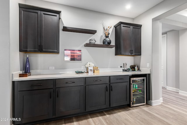 bar with wine cooler and light wood-type flooring