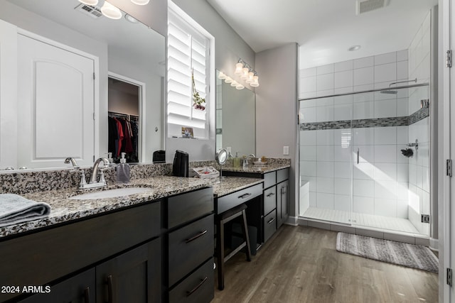 bathroom featuring vanity, hardwood / wood-style flooring, and a shower with door