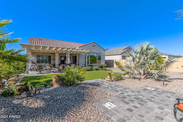 rear view of property featuring a yard and a patio area