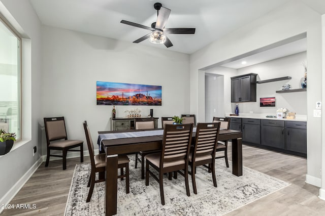 dining space with light wood-type flooring and ceiling fan