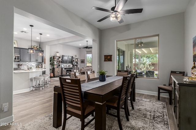 dining area with light wood-type flooring and ceiling fan