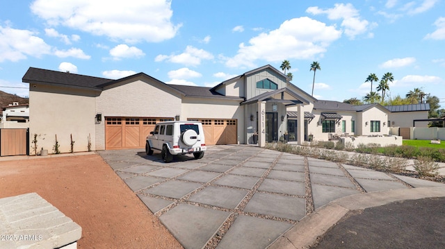 modern farmhouse style home with concrete driveway, an attached garage, fence, and stucco siding