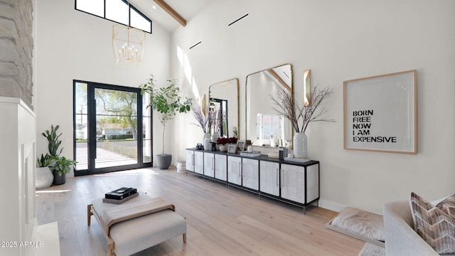 entrance foyer featuring baseboards, beamed ceiling, an inviting chandelier, wood finished floors, and high vaulted ceiling