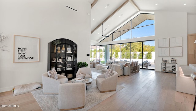 living area with beamed ceiling, high vaulted ceiling, and hardwood / wood-style flooring