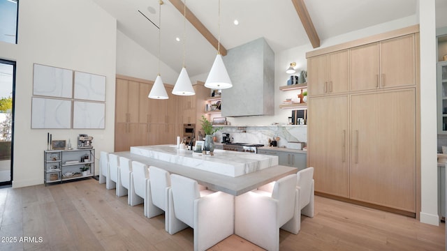 kitchen featuring light brown cabinetry, light wood-type flooring, beam ceiling, high vaulted ceiling, and open shelves