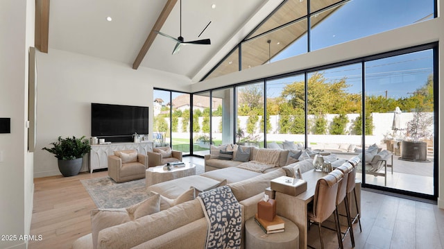 living room featuring ceiling fan, beam ceiling, light wood finished floors, and high vaulted ceiling