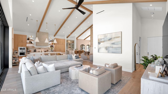 living room featuring visible vents, high vaulted ceiling, beam ceiling, ceiling fan, and light wood-style floors