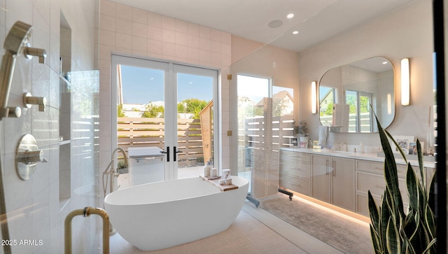 bathroom with a tile shower, recessed lighting, a freestanding bath, and vanity