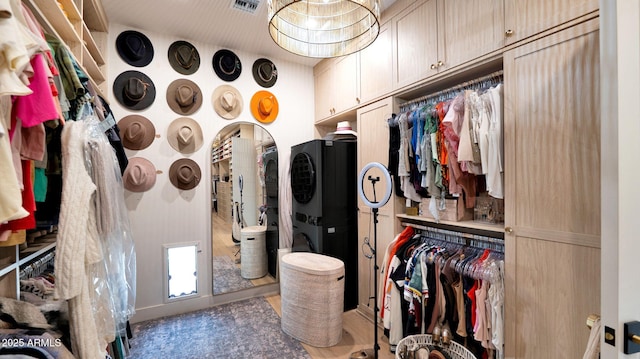 spacious closet featuring visible vents and stacked washing maching and dryer