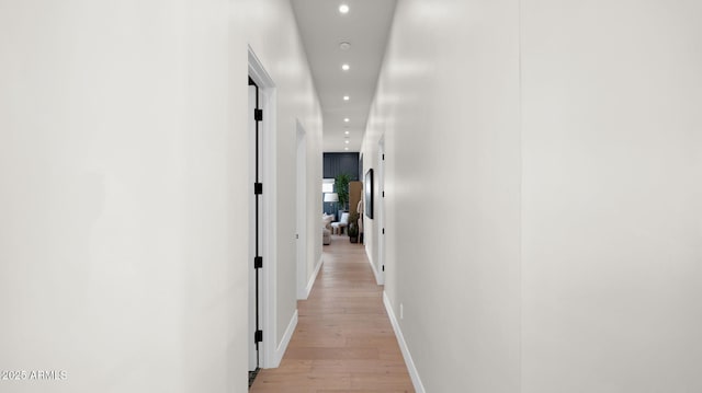 corridor featuring light wood finished floors, recessed lighting, and baseboards