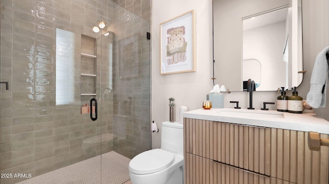 bathroom featuring a shower stall, toilet, and vanity