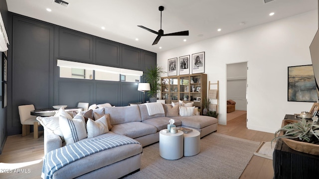 living room featuring a ceiling fan, visible vents, baseboards, recessed lighting, and light wood-style floors