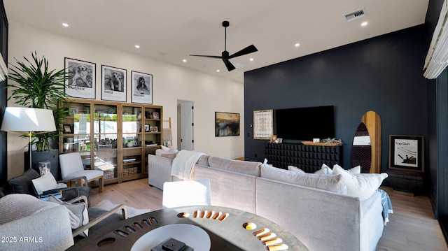 living room featuring visible vents, recessed lighting, ceiling fan, a towering ceiling, and light wood-type flooring