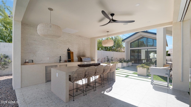 view of patio / terrace with fence, outdoor wet bar, area for grilling, ceiling fan, and a grill