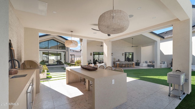 view of patio featuring area for grilling, outdoor dining area, ceiling fan, a sink, and an outdoor hangout area