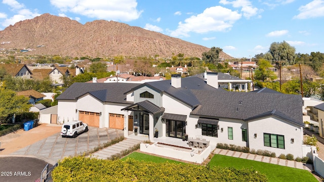 rear view of property with a residential view, a mountain view, a garage, and fence