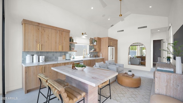 kitchen featuring visible vents, high vaulted ceiling, open shelves, tasteful backsplash, and light countertops