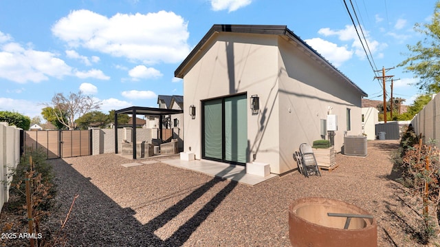 back of house with stucco siding, cooling unit, a patio, and a fenced backyard