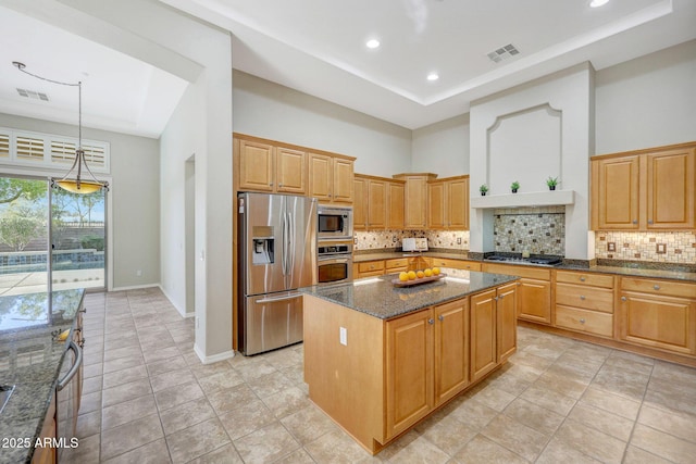 kitchen with a high ceiling, visible vents, stainless steel appliances, and a center island