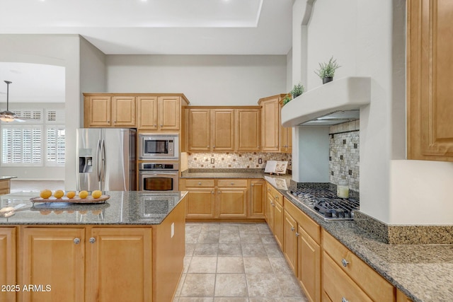 kitchen featuring light tile patterned flooring, light brown cabinets, appliances with stainless steel finishes, backsplash, and dark stone counters