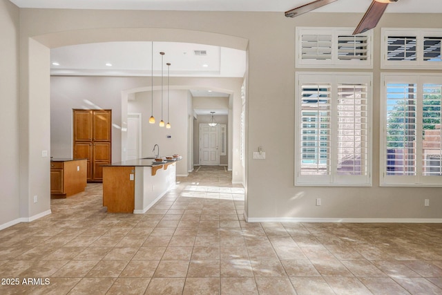 entrance foyer featuring arched walkways, light tile patterned floors, recessed lighting, visible vents, and baseboards