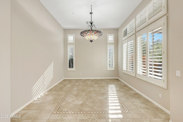 unfurnished dining area featuring plenty of natural light and baseboards