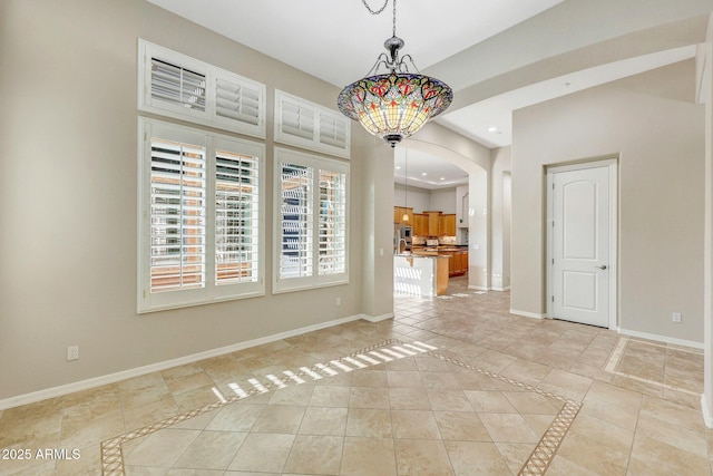 unfurnished dining area with recessed lighting, light tile patterned flooring, and baseboards