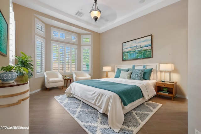 bedroom featuring wood finished floors, visible vents, and baseboards